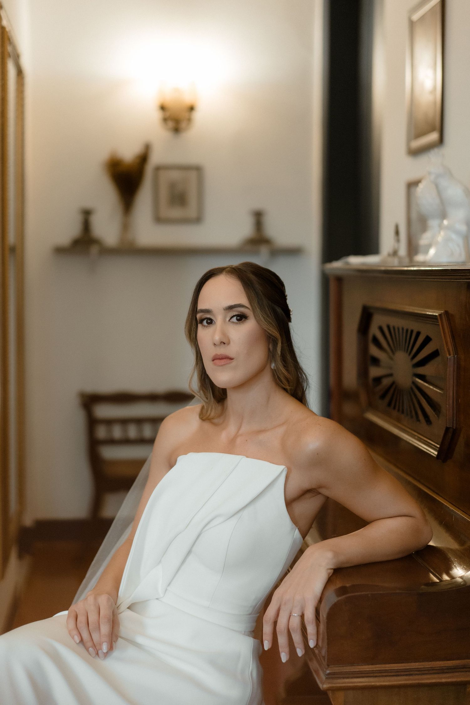 Romantic bridal portraits featuring an elegant white strapless gown against wooden architectural details.