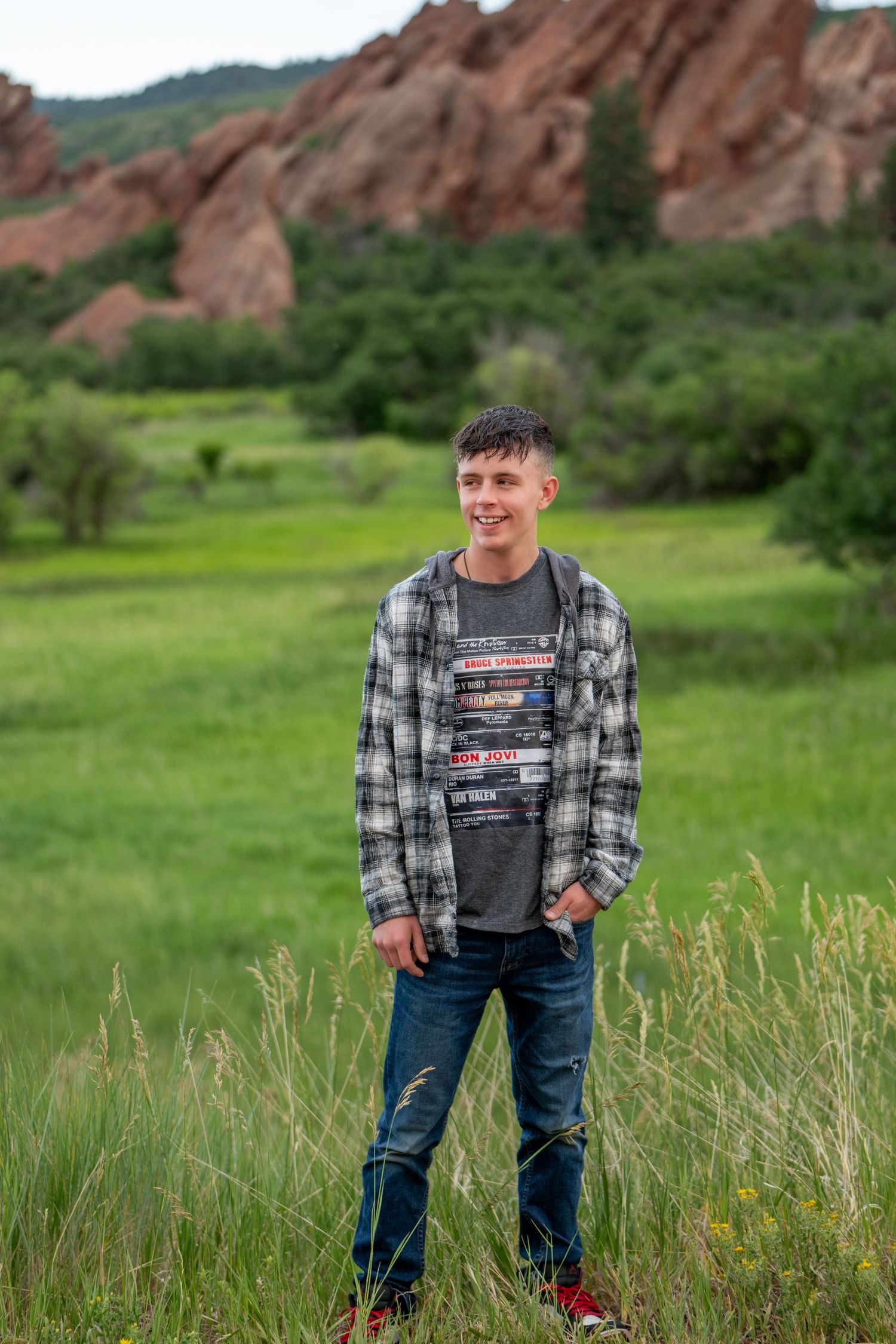 Scenic portrait at Roxborough State Park in Colorado with dramatic red rock formations and green meadow in background.
