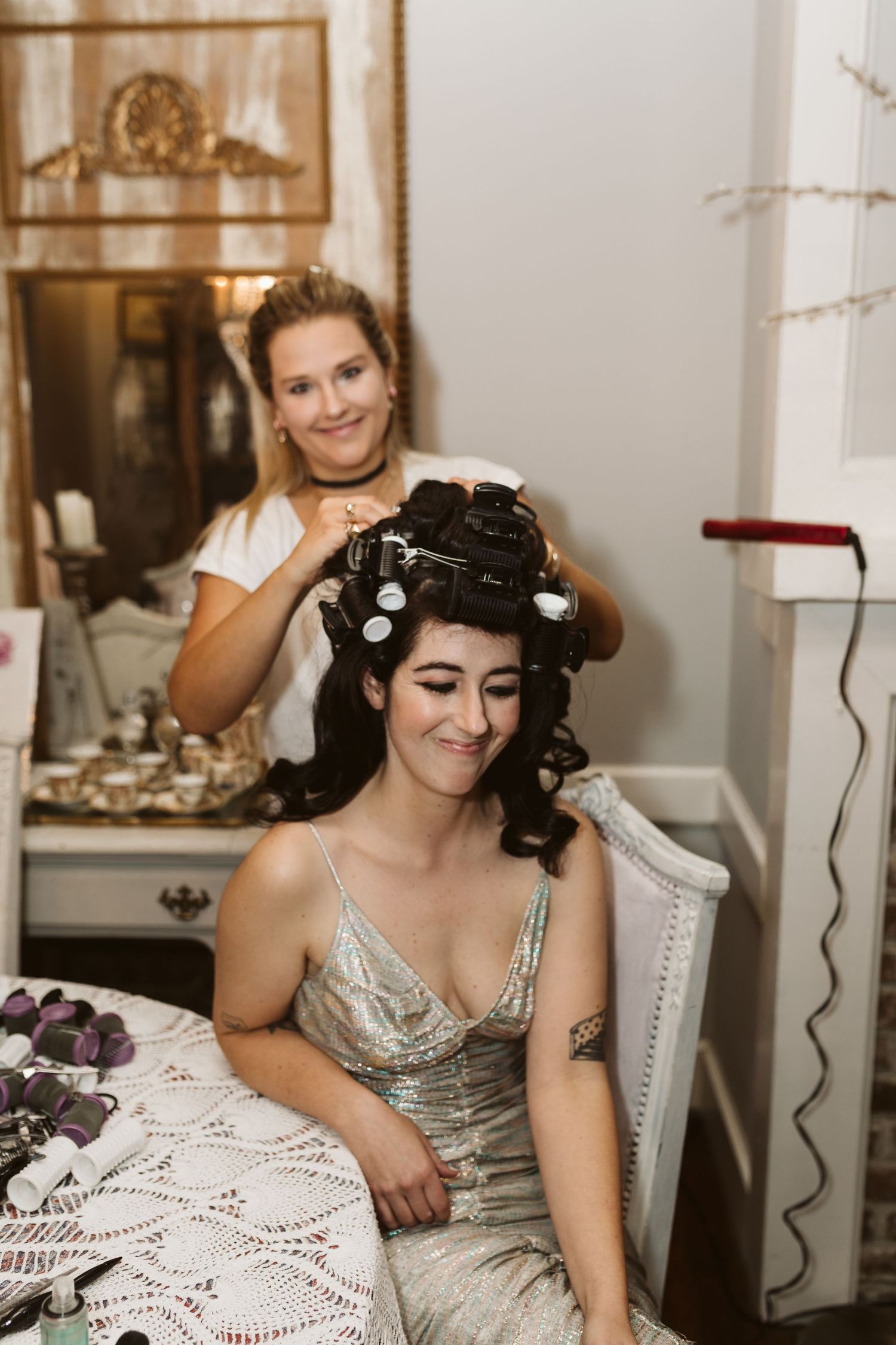 Group sitting in elegant white chairs during wedding preparations.