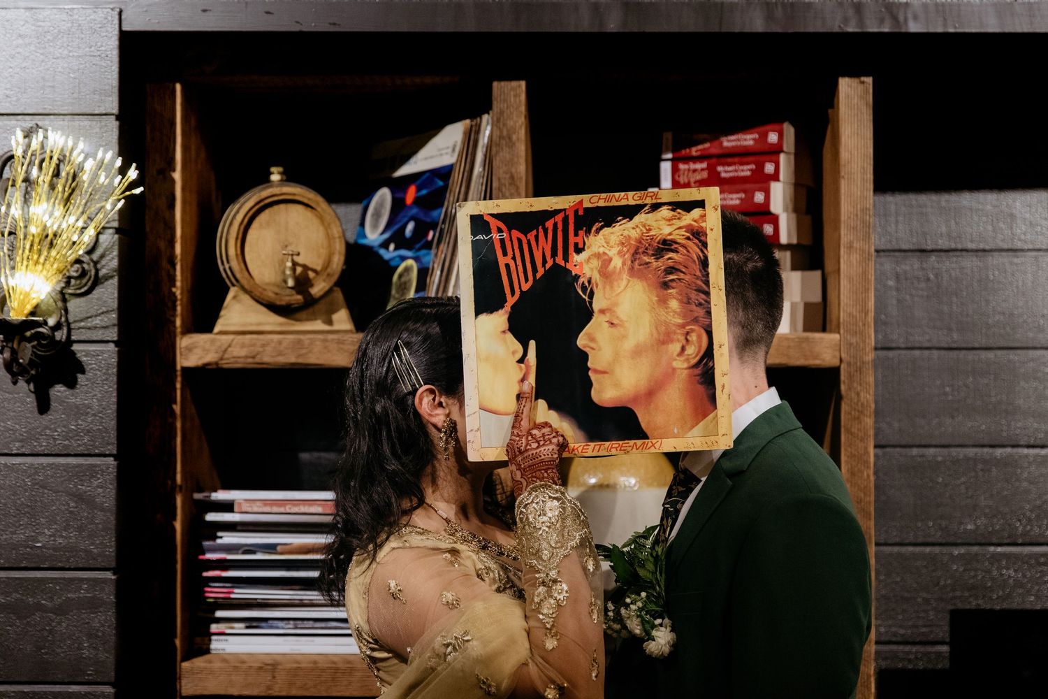 Auckland wedding photographer capturing a creative couple holding a David Bowie ‘China Girl’ record in front of their faces.