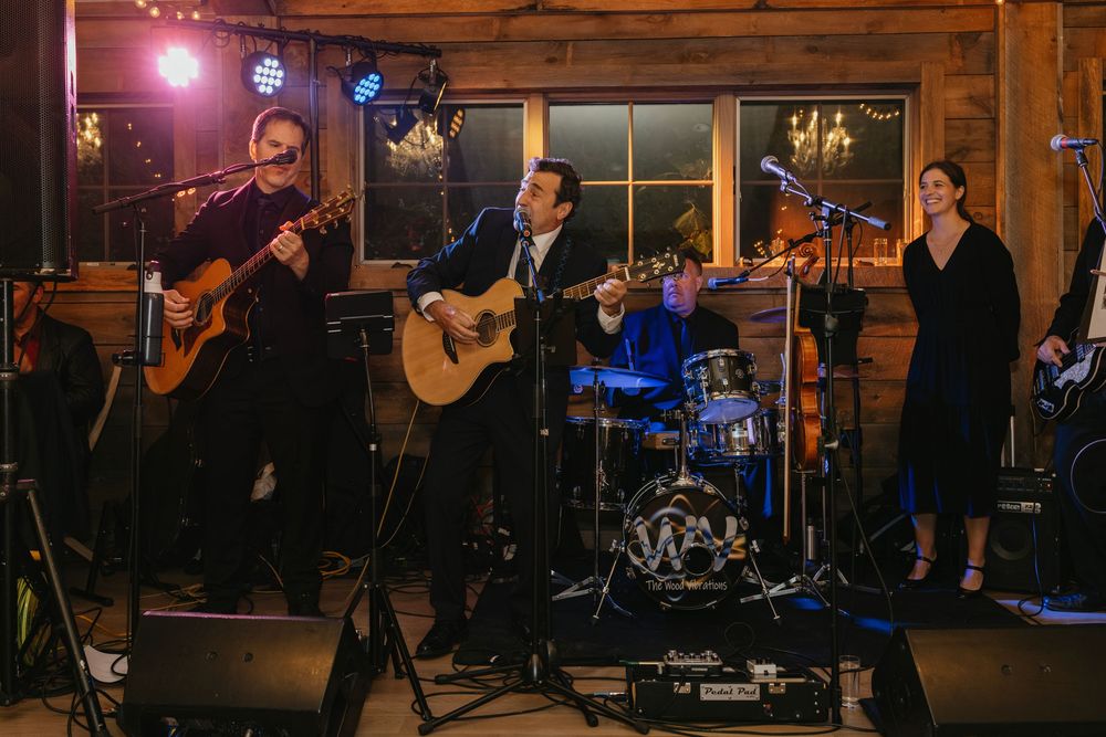 Musicians perform at an elegant rustic venue with warm lighting and wooden interior decor.