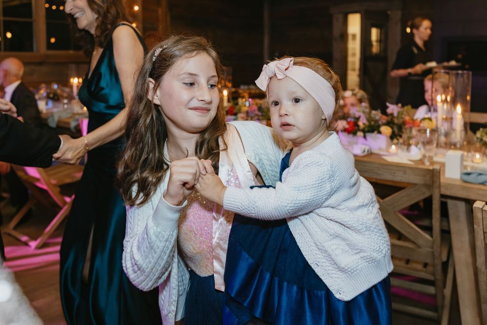 People dance and celebrate at an evening wedding reception with warm lighting and festive atmosphere.