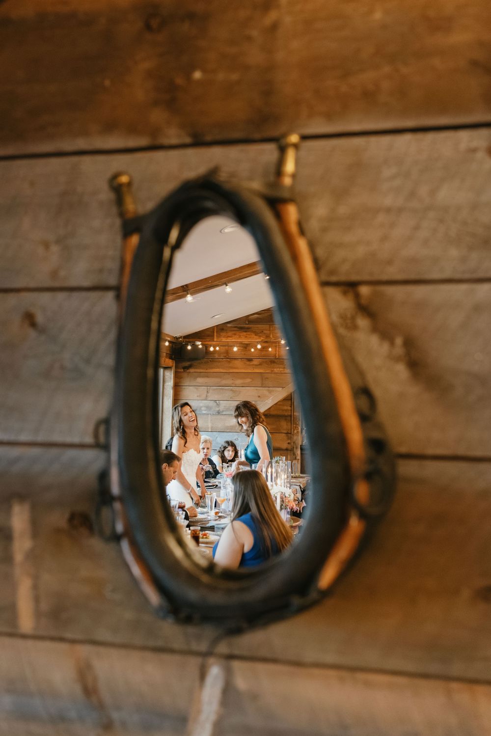 A sequence of wedding moments captured through rustic horseshoe frames mounted on wooden walls.