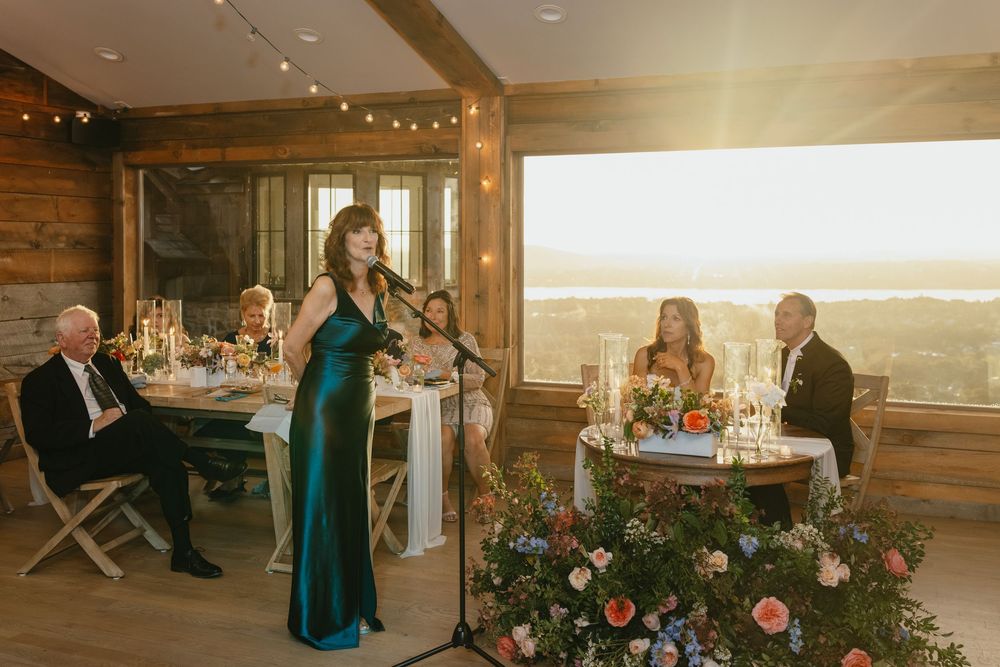Wedding reception venue with rustic wooden beams and twinkling string lights creating a warm, romantic atmosphere.