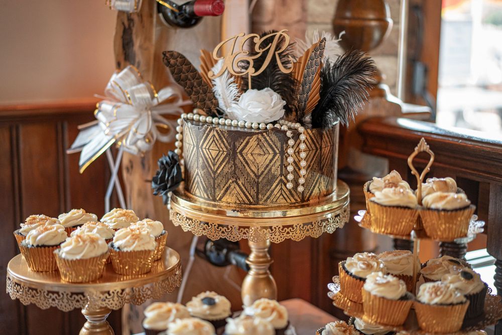 Decorative cupcake tower with white frosted treats displayed on an elegant gold stand for a wedding.
