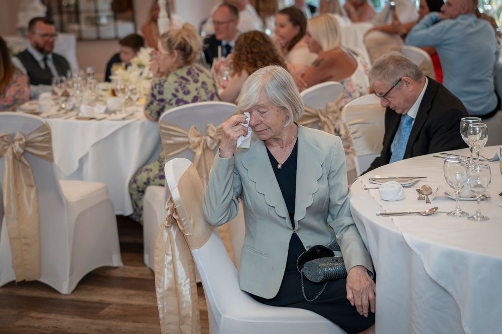 Guests enjoying conversation at elegant reception tables with white linens and formal place settings.