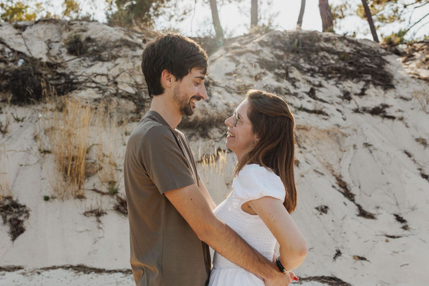 Romantic engagement portrait of couple embracing on the beach in Tróia Setúbal