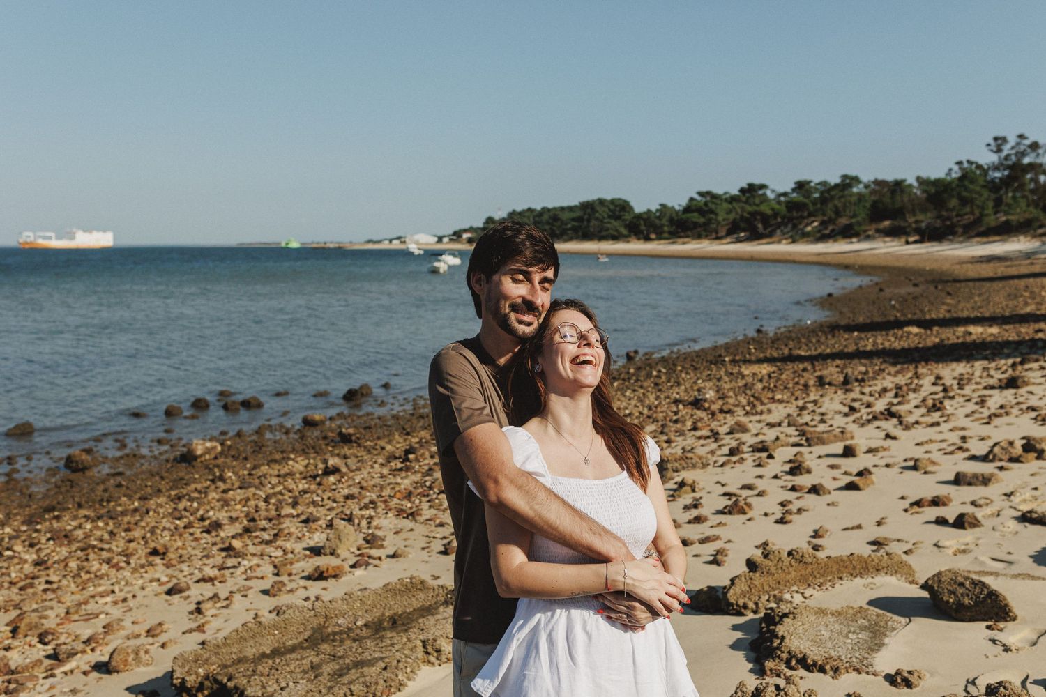 Happy couple laughing together during engagement photoshoot on the beach in Setúbal