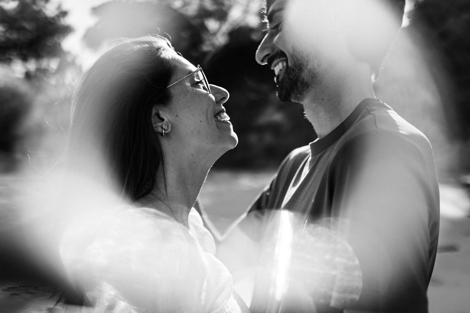 Black and white close-up of couple smiling during intimate engagement session in Tróia