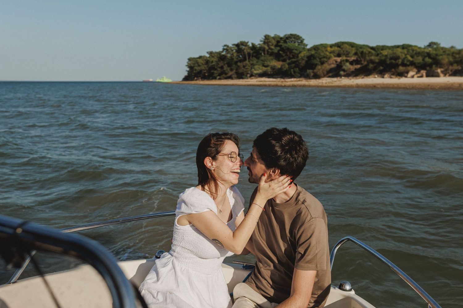 Couple enjoying a boat ride during engagement photoshoot in Tróia Setúbal