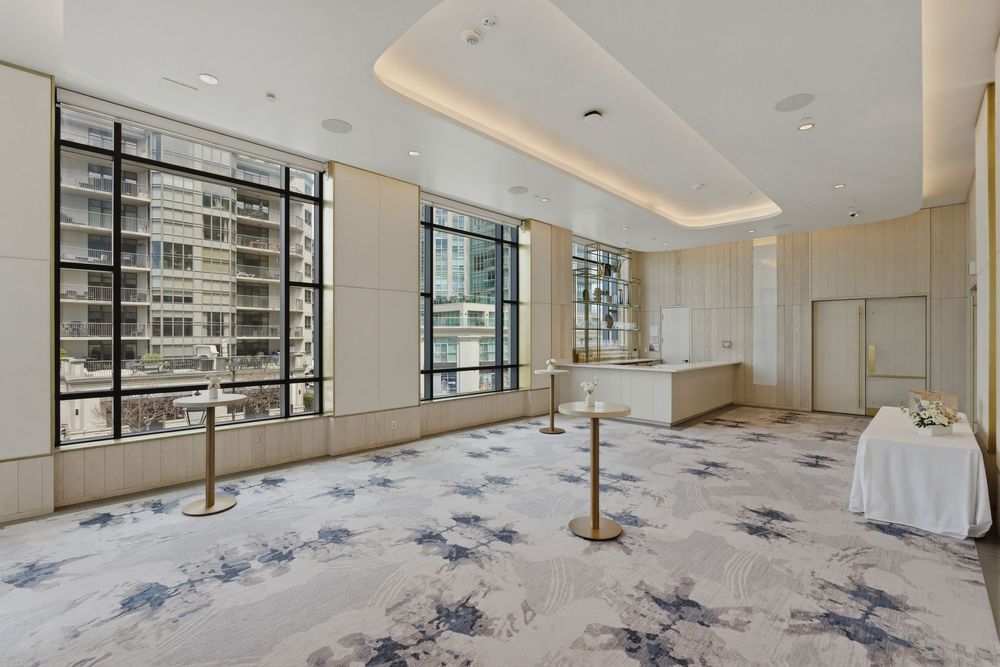 A bright, modern dance studio with mirrored walls, ballet barres, and a patterned gray carpet stretches into the distance.