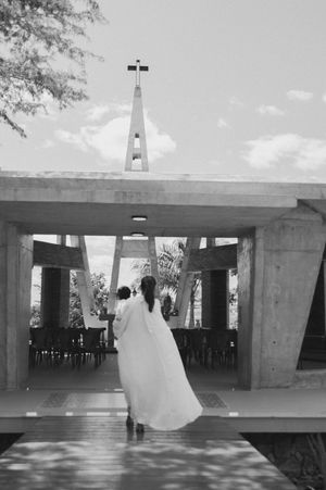 A black and white photo series showing figures walking through a modernist concrete building with dramatic lighting.