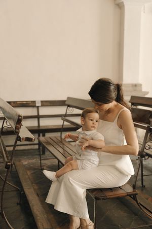 A series of photos showing a tender moment between parent and child sitting on wooden benches in a white room.