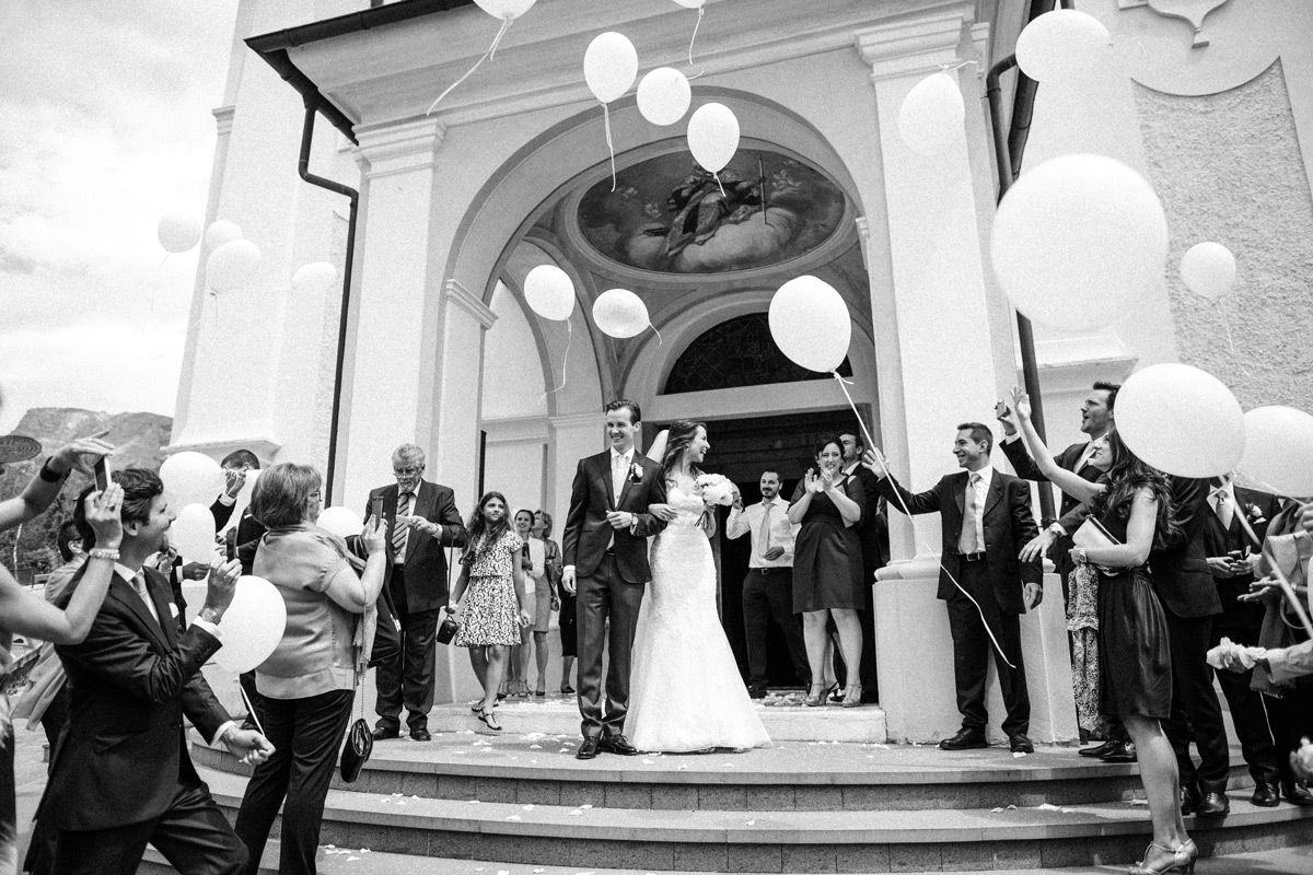 Bride and groom leaving st. ulrich church after wedding ceremony in the Dolomites