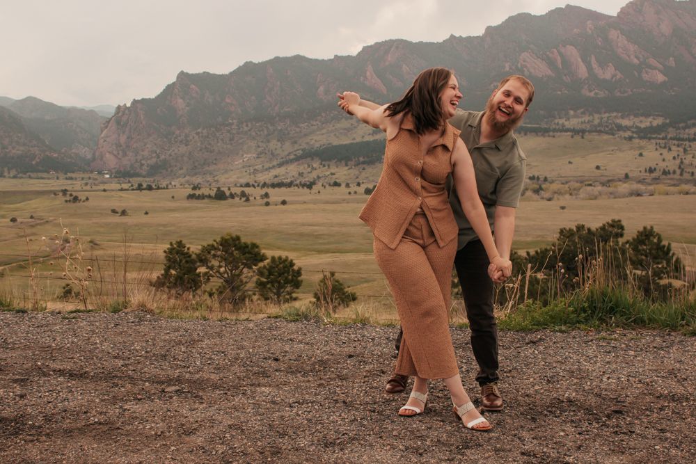 Couple embracing on a rocky overlook with scenic mountain views | What to Wear for Family Photos