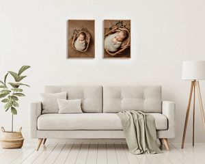 Two framed newborn portrait photos displayed above a beige sofa in a bright minimalist living room with wooden floors.