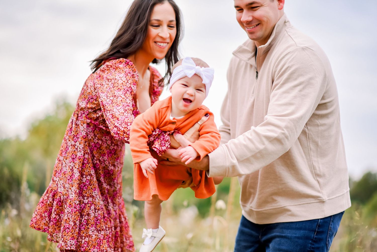 A couple and their baby share joyful moments together in a series of candid outdoor family photos.