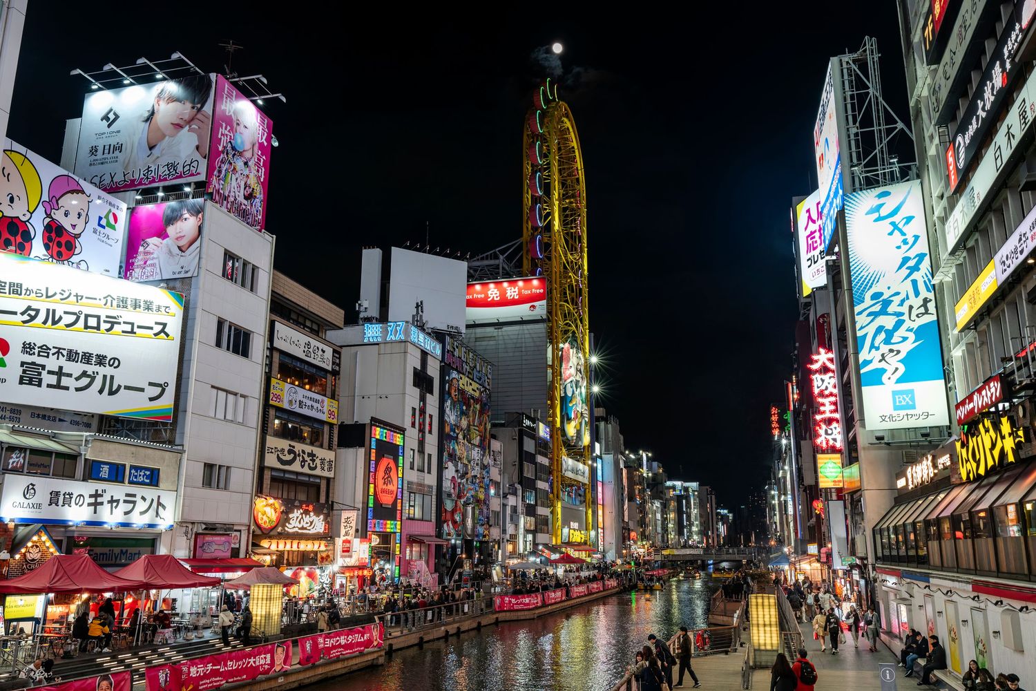 Vibrant Dotonbori canal district at night with neon signs and reflections in Osaka, Japan.
