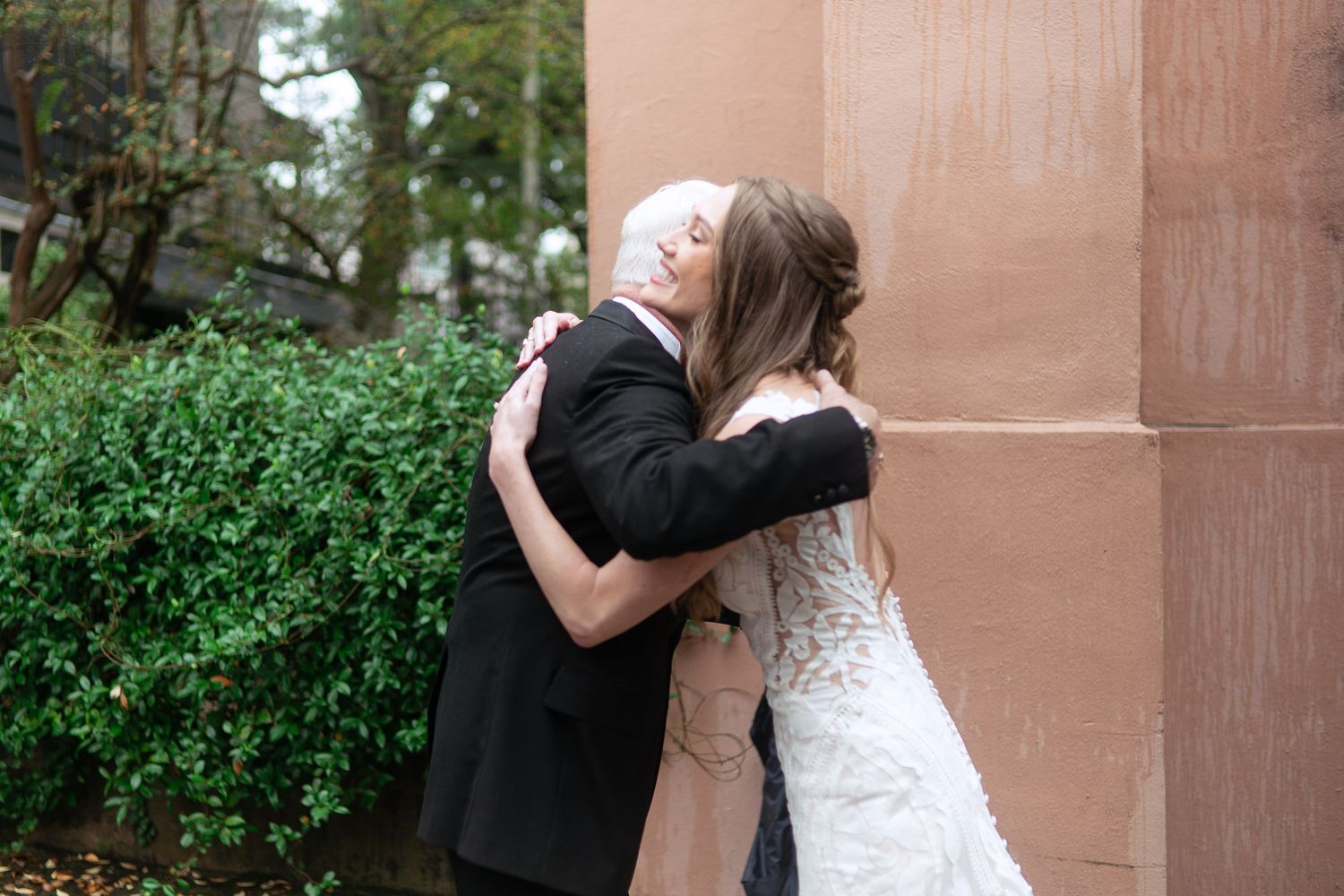 Romantic outdoor wedding portraits against stone architecture and lush greenery.