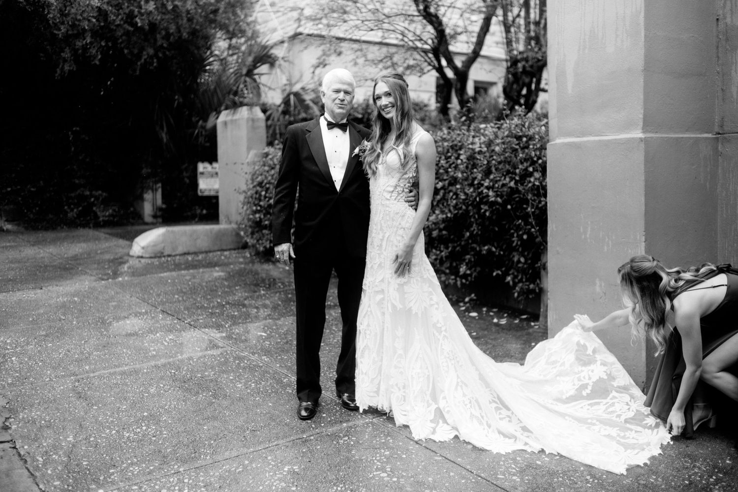 Wedding ceremony procession in an elegant outdoor setting with trailing bridal gown.