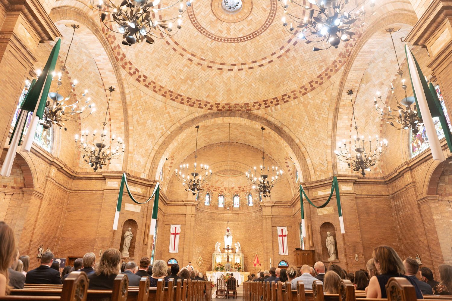 Ornate cathedral ceiling with crystal chandeliers and intricate gold architectural details.