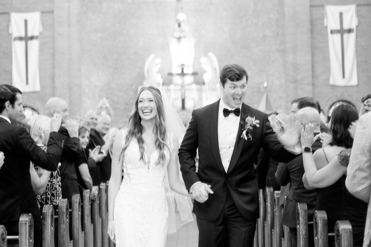 Wedding celebration inside historic church with elegant chandeliers and wooden pews.