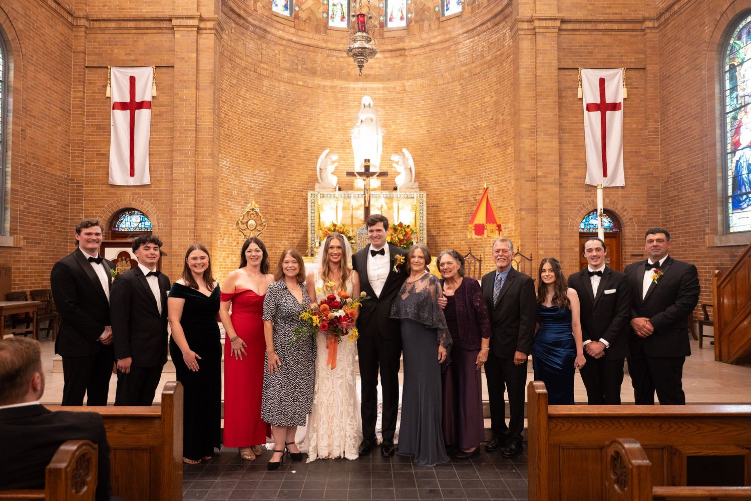 Wedding party lineup in a grand church sanctuary with warm lighting and architectural details.
