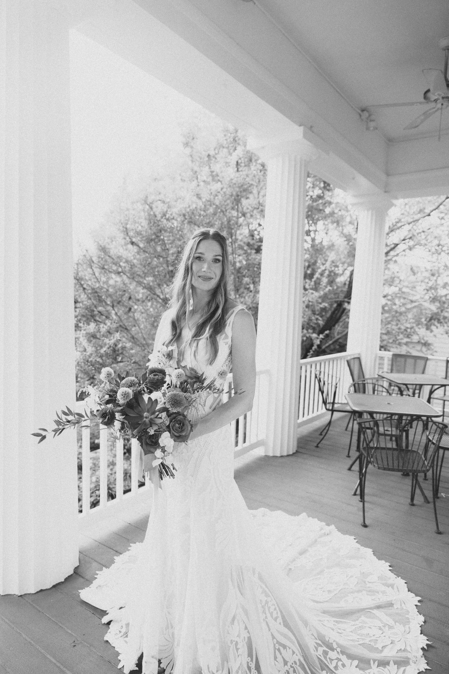 Elegant bridal portrait session on a classic Southern white columned porch in natural light.