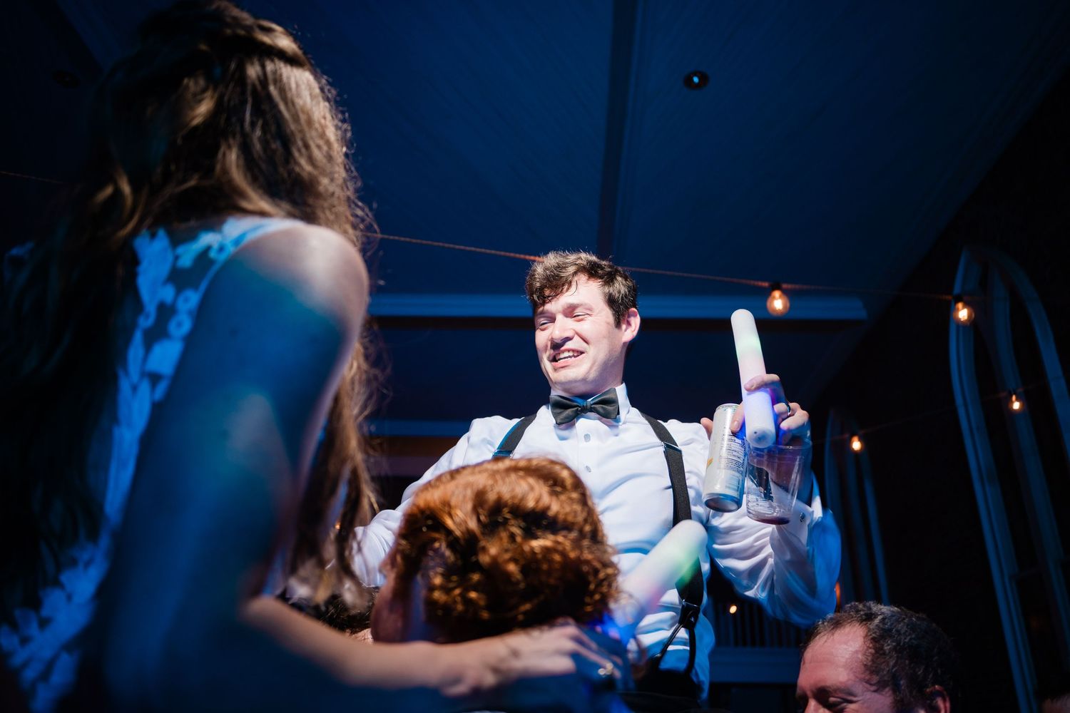 Dance floor celebration under dramatic blue lighting with guests enjoying the festivities.