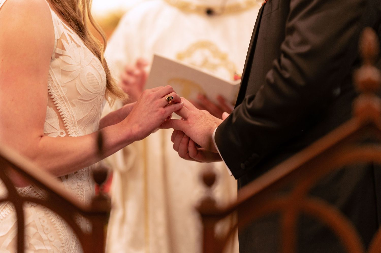 Close-up of couple exchanging wedding rings during traditional church ceremony.