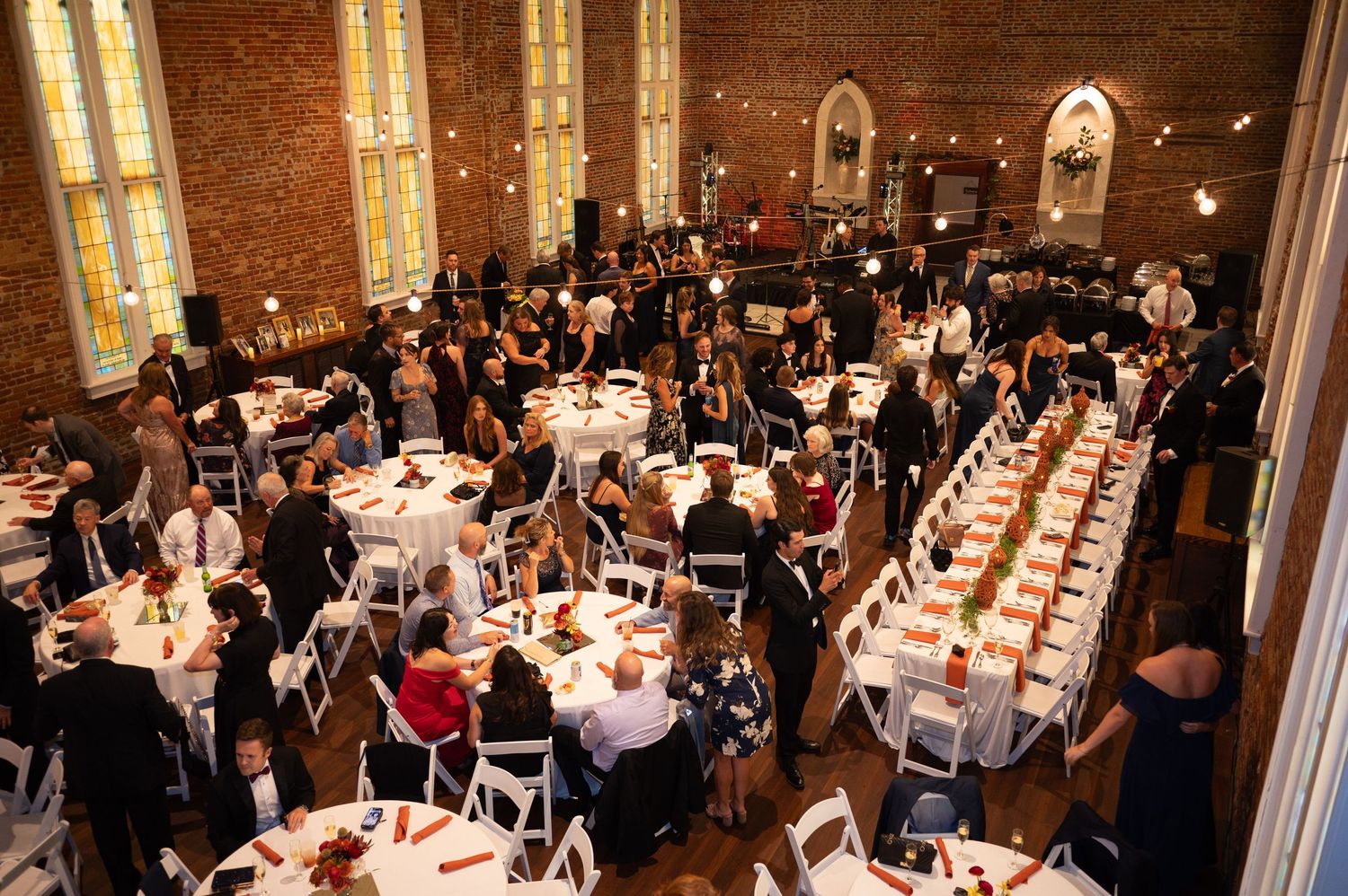 Large banquet hall filled with guests seated at long tables for an elegant dinner reception.
