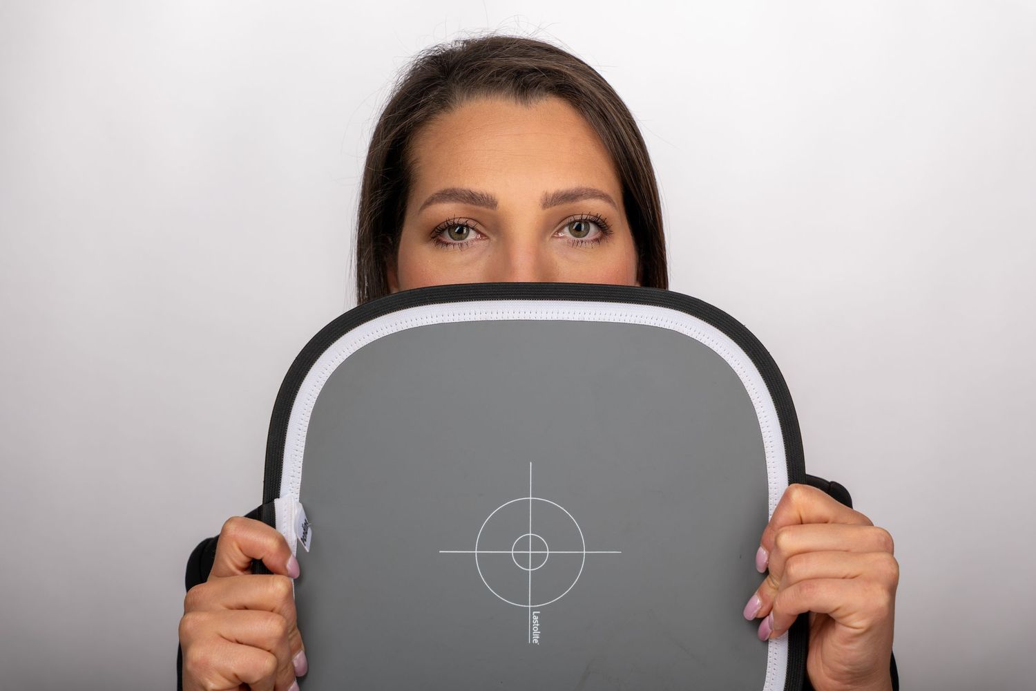A sequence of photos showing someone holding up gray semicircular objects with target marks against a white background.