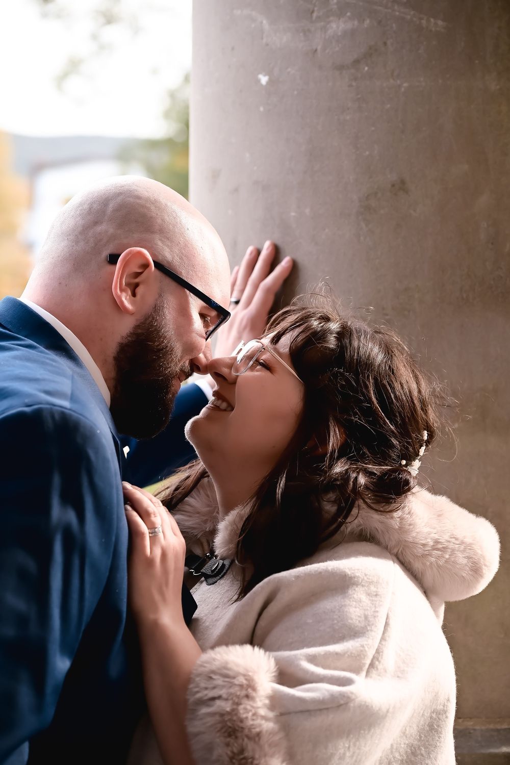 newlywed couple kissing leaning against pillar at Government House in backlit golden light, St. John's Newfoundland wedding photography