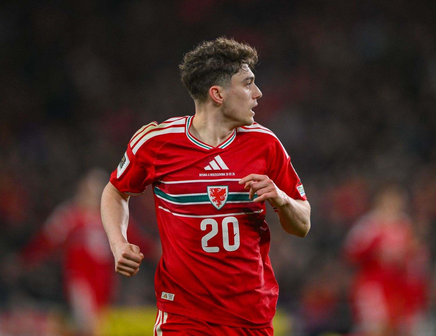 Wales footballer wearing red number 20 jersey during an international match at a stadium.