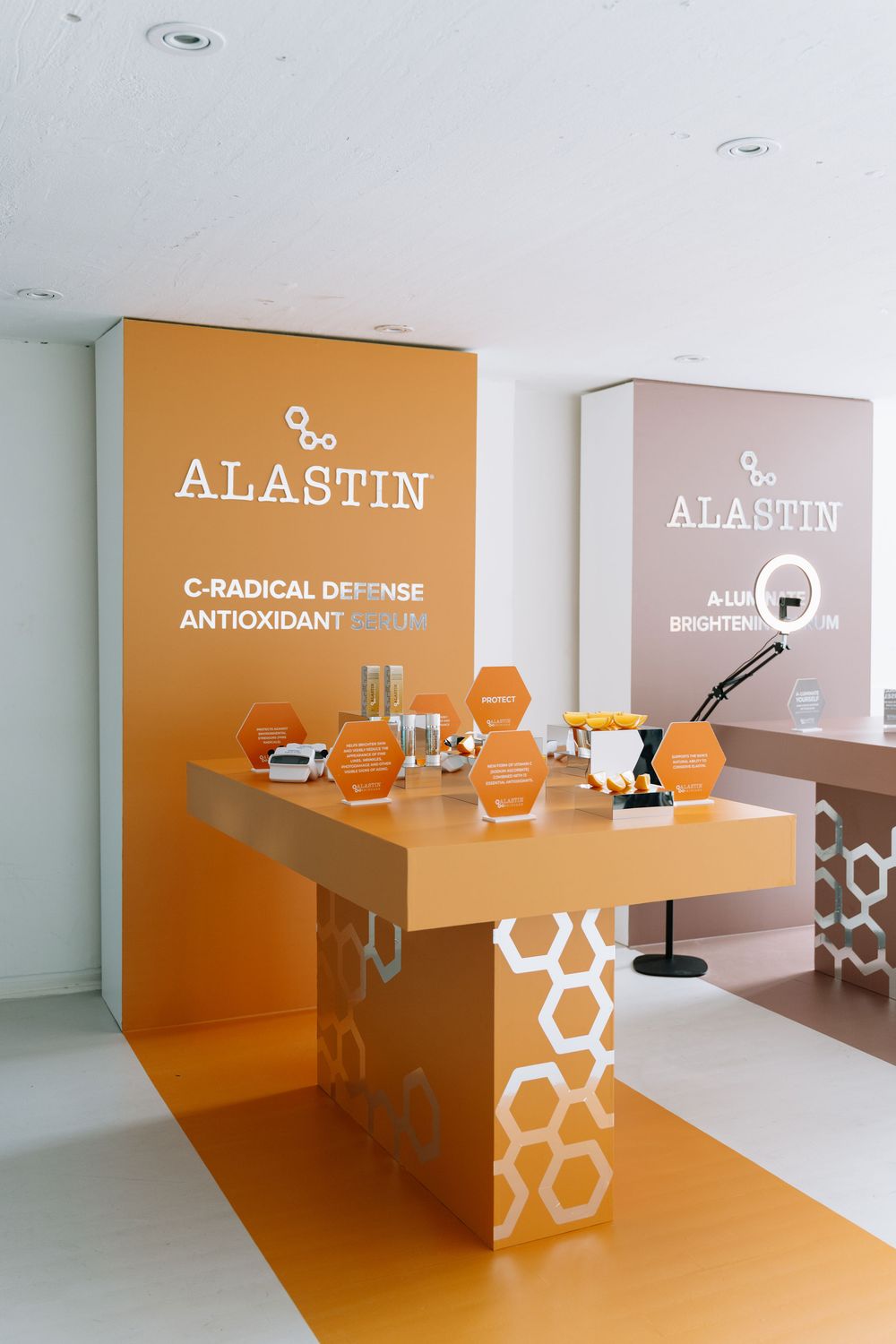 Modern office reception area with orange hexagonal design elements and white signage on walls.