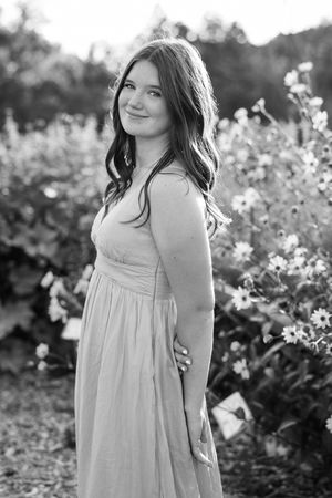A collection of black and white portraits featuring a flowing white dress against natural foliage.