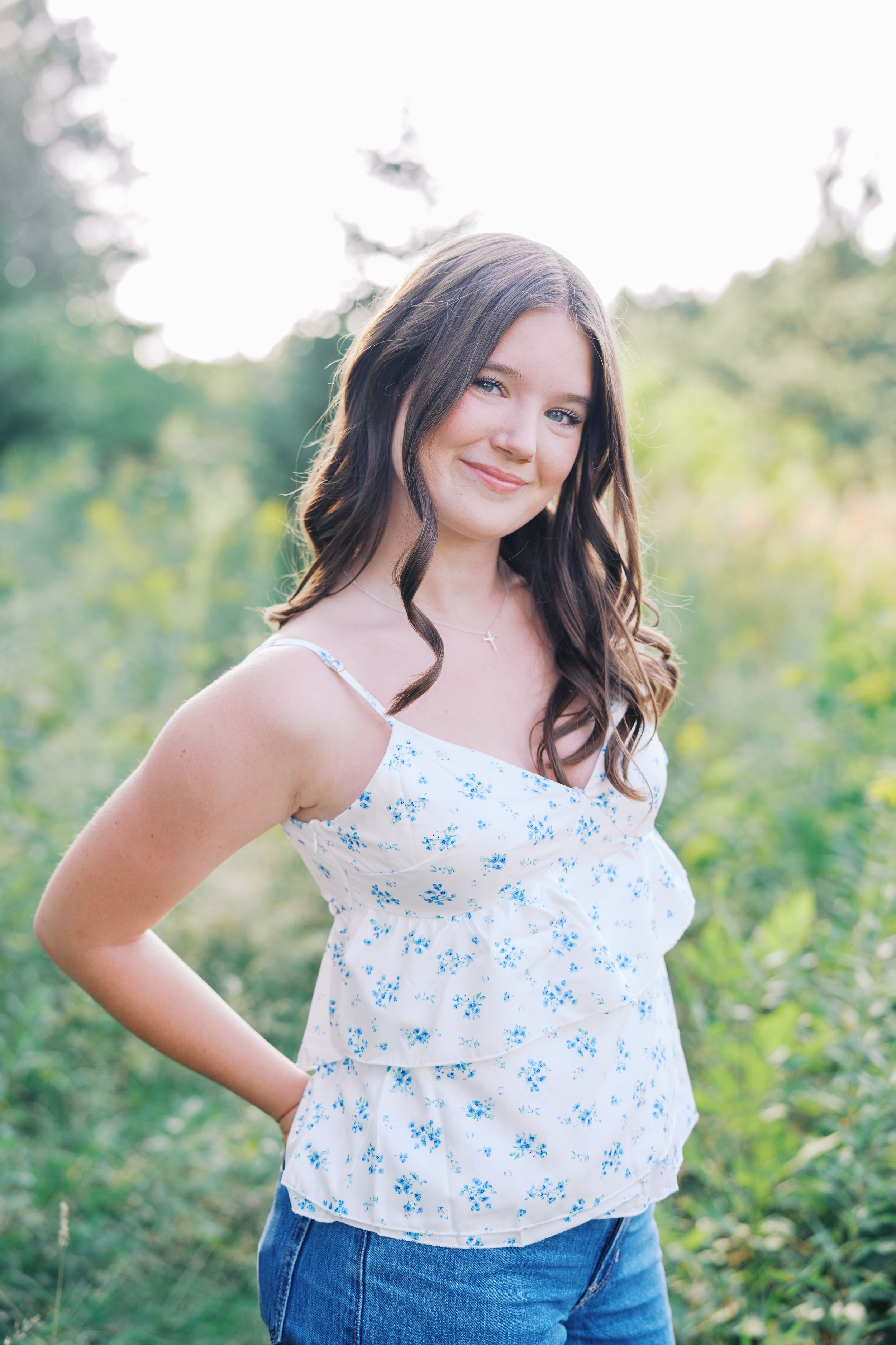 Summer portrait in wildflowers wearing a blue floral camisole top.