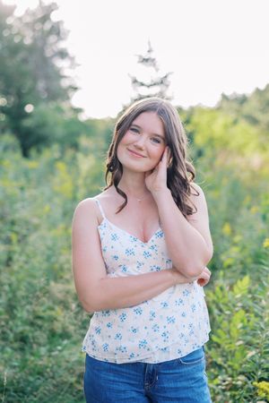 Candid outdoor portrait in a meadow with soft natural lighting and wildflowers.