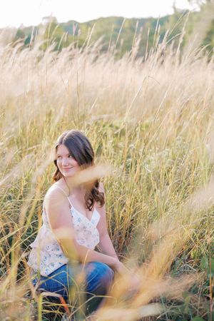 Candid outdoor photoshoot in golden wheat field with casual summer attire.