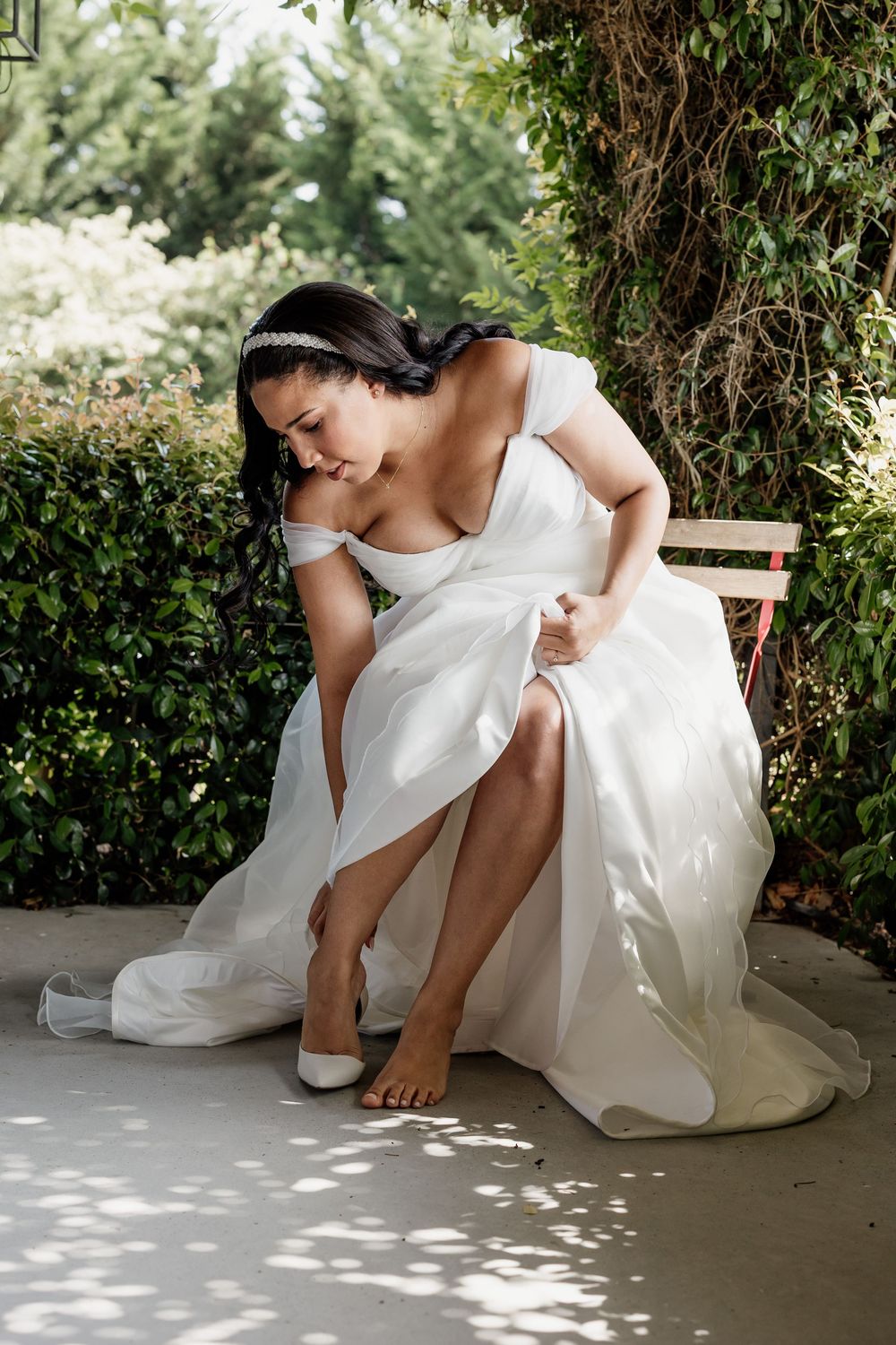 A series of photos showing someone in a white wedding dress sitting on a bench in a garden setting.