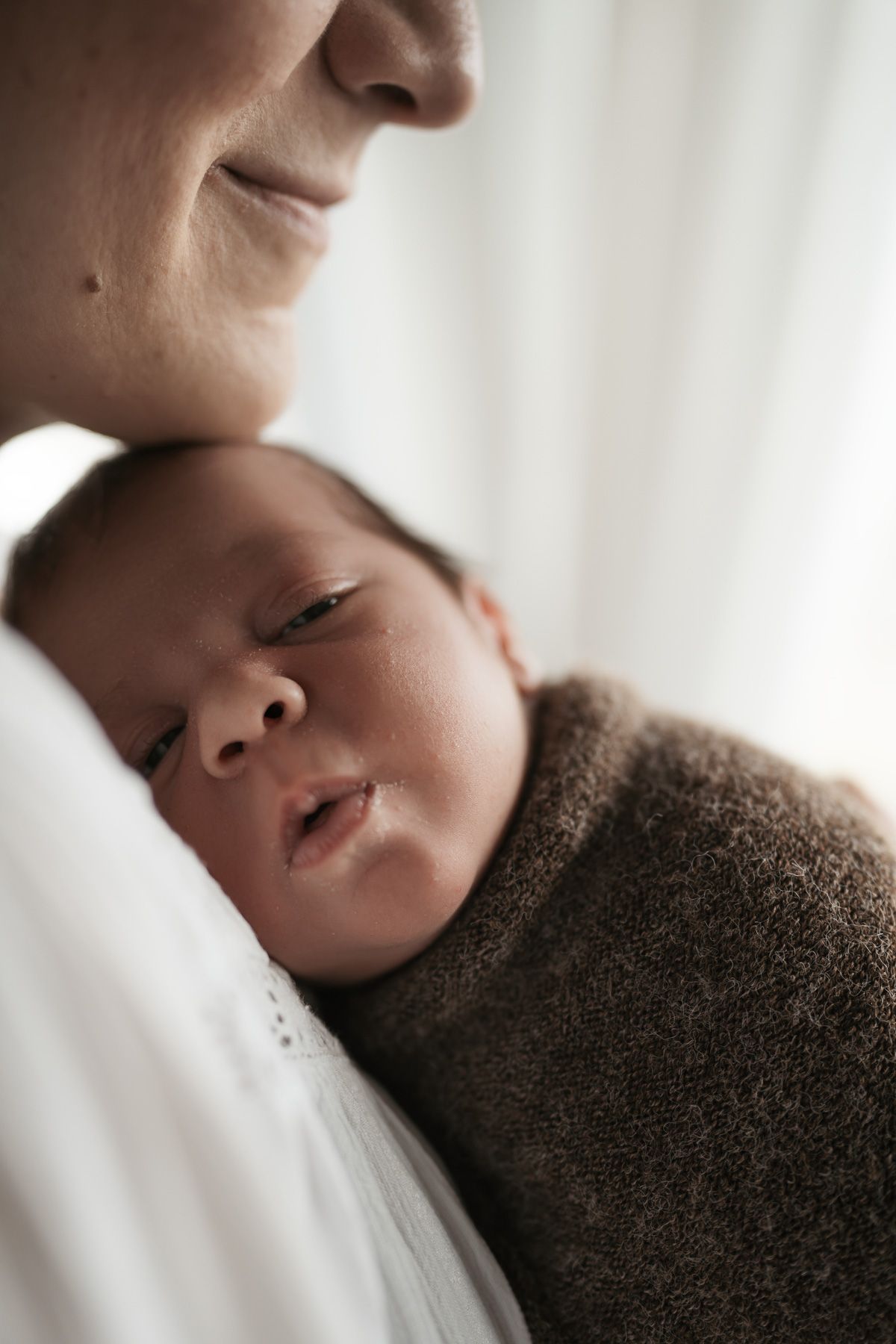 A series of close-up shots showing a sleeping baby's face from different angles against a soft white background.