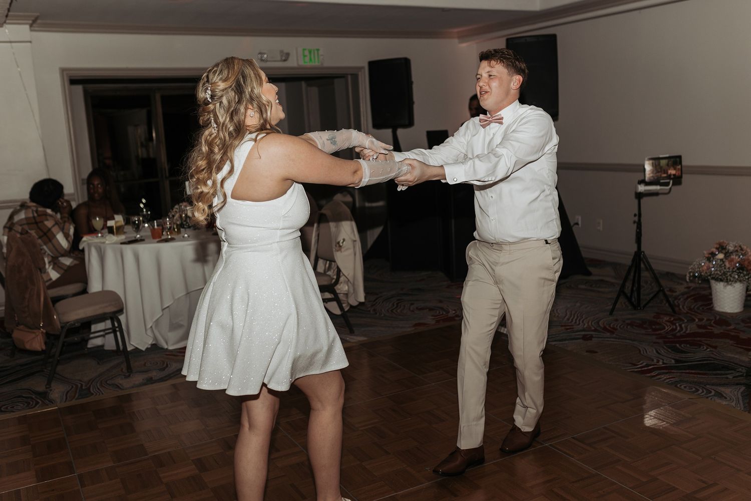 A couple dances together at a wedding reception in a ballroom at Singing Hills Golf Resort.