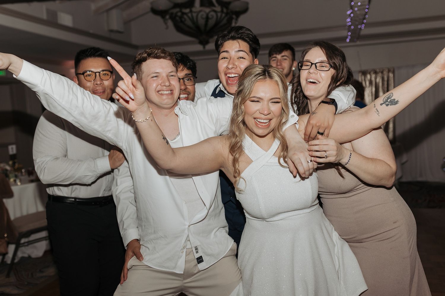 Wedding party celebrates joyfully on the dance floor during reception festivities at Singing Hills Golf Resort.