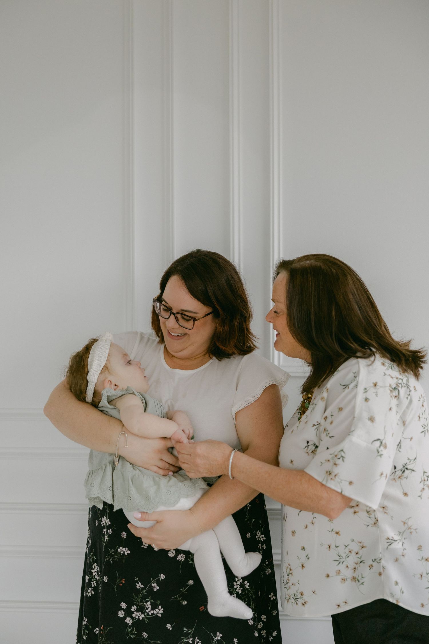 Two people in black and white floral outfits share playful and joyful moments in a sequence of candid photos.
