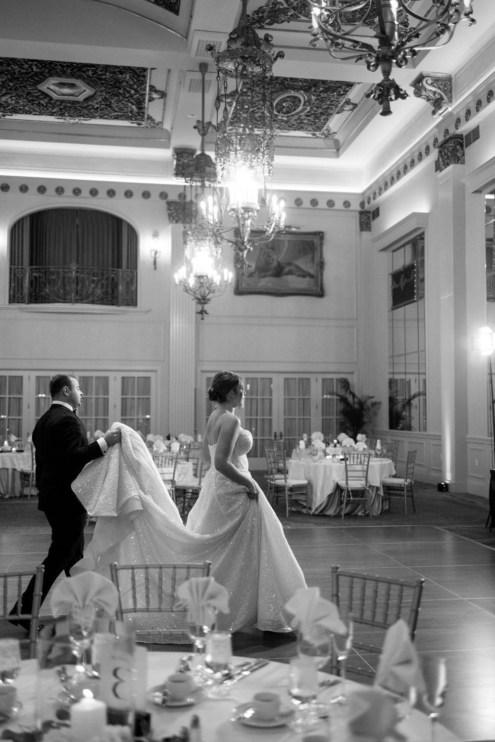 The Pfister Hotel ballroom photo of bride and groom dancing in elegant ballroom with chandeliers during wedding reception.