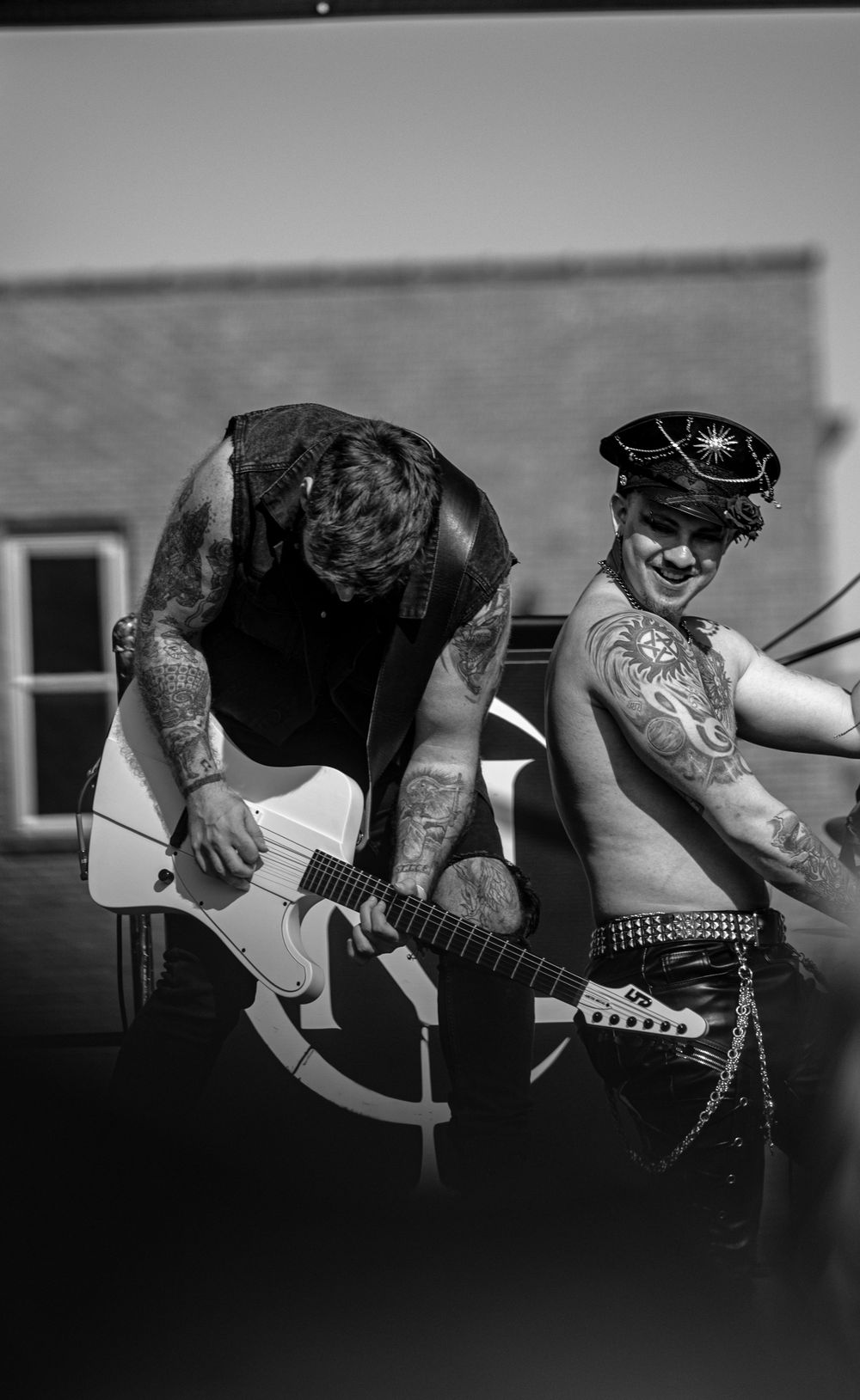 Black and white panoramic photo sequence showing close-up details of a guitarist playing an electric guitar.