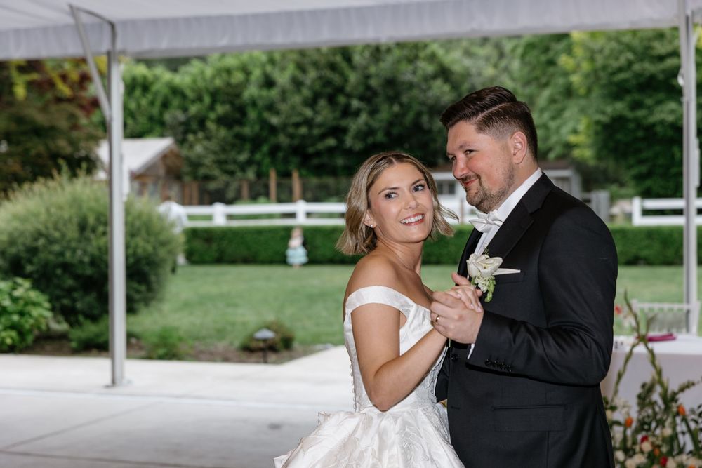 A bride and groom share a romantic moment together during their outdoor wedding ceremony.