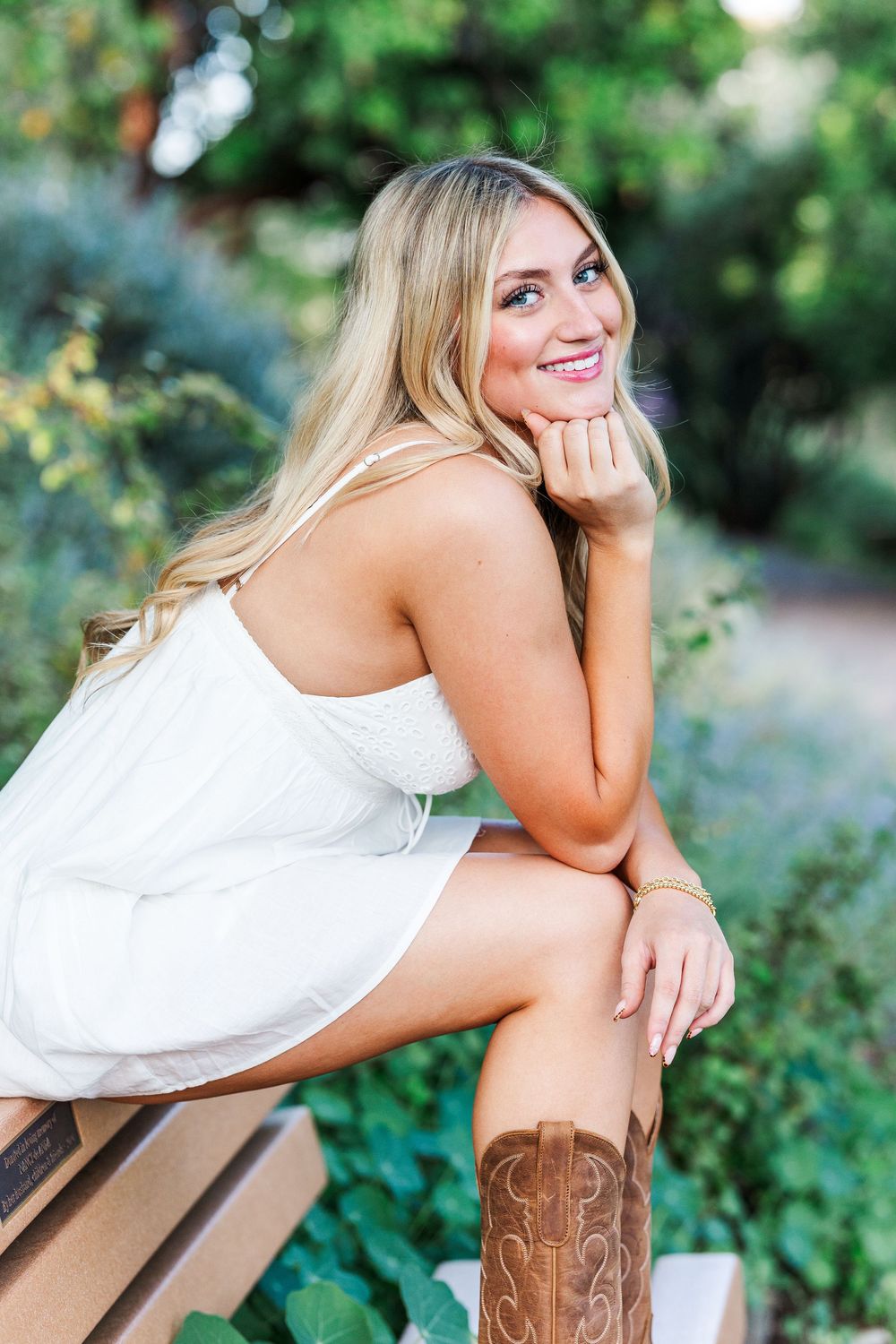 Artistic outdoor portraits taken on a wooden bench surrounded by lush greenery.