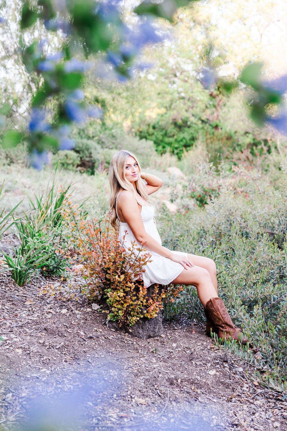Candid outdoor photography session with rustic elements and flowering bushes.