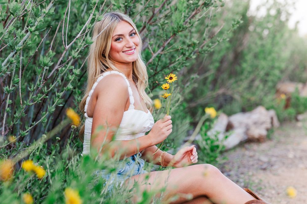Summer portrait session in a wildflower field with yellow blooms and natural lighting.